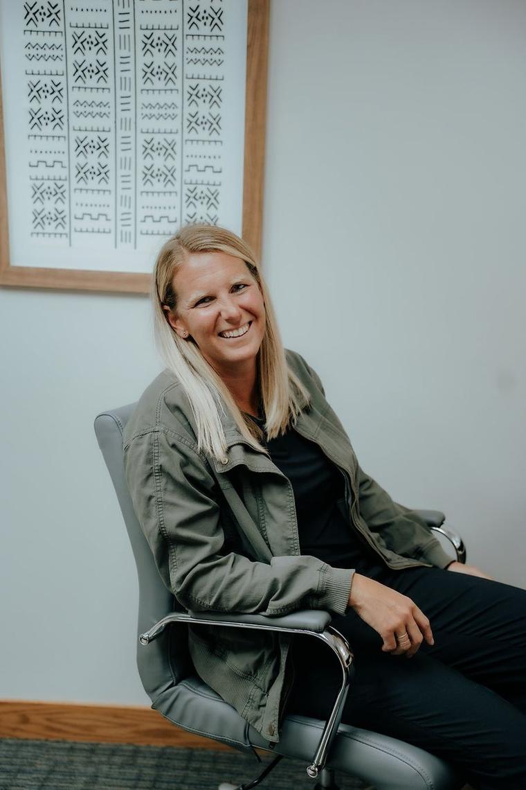 Anna Psaute seated in her office, laughing.
