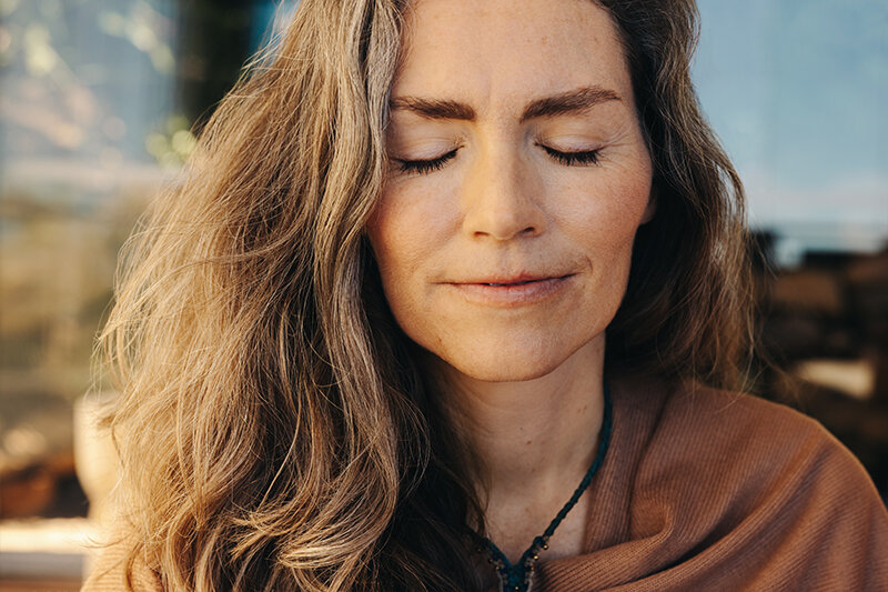 A woman stands with her hands crossed over her chest.