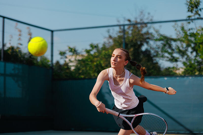 A young athlete mid-swing on a padel court.